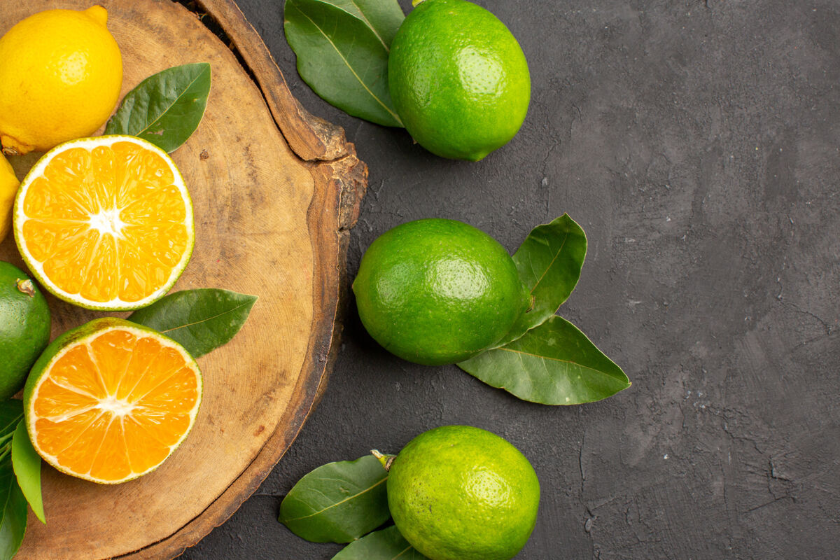 酸橙在深色的餐桌上俯瞰新鲜柠檬酸橙水果柑橘新鲜柠檬水果健康