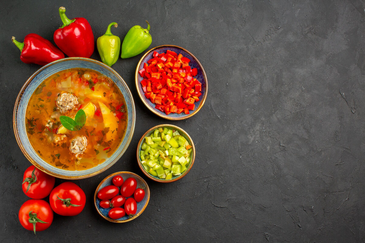 食物俯瞰美味的肉汤配上新鲜蔬菜上深色餐桌上的菜肴照片美食餐厅胡椒蔬菜