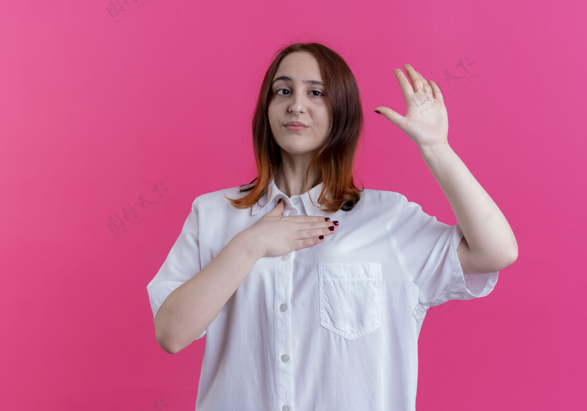 手势年轻的红发女孩把手放在胸前 在粉红色的墙上显示停止的手势年轻表演停