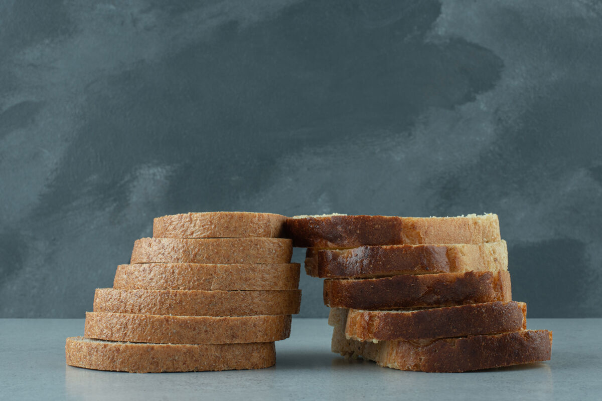 硬皮石头桌上的新鲜面包片谷类食品面包