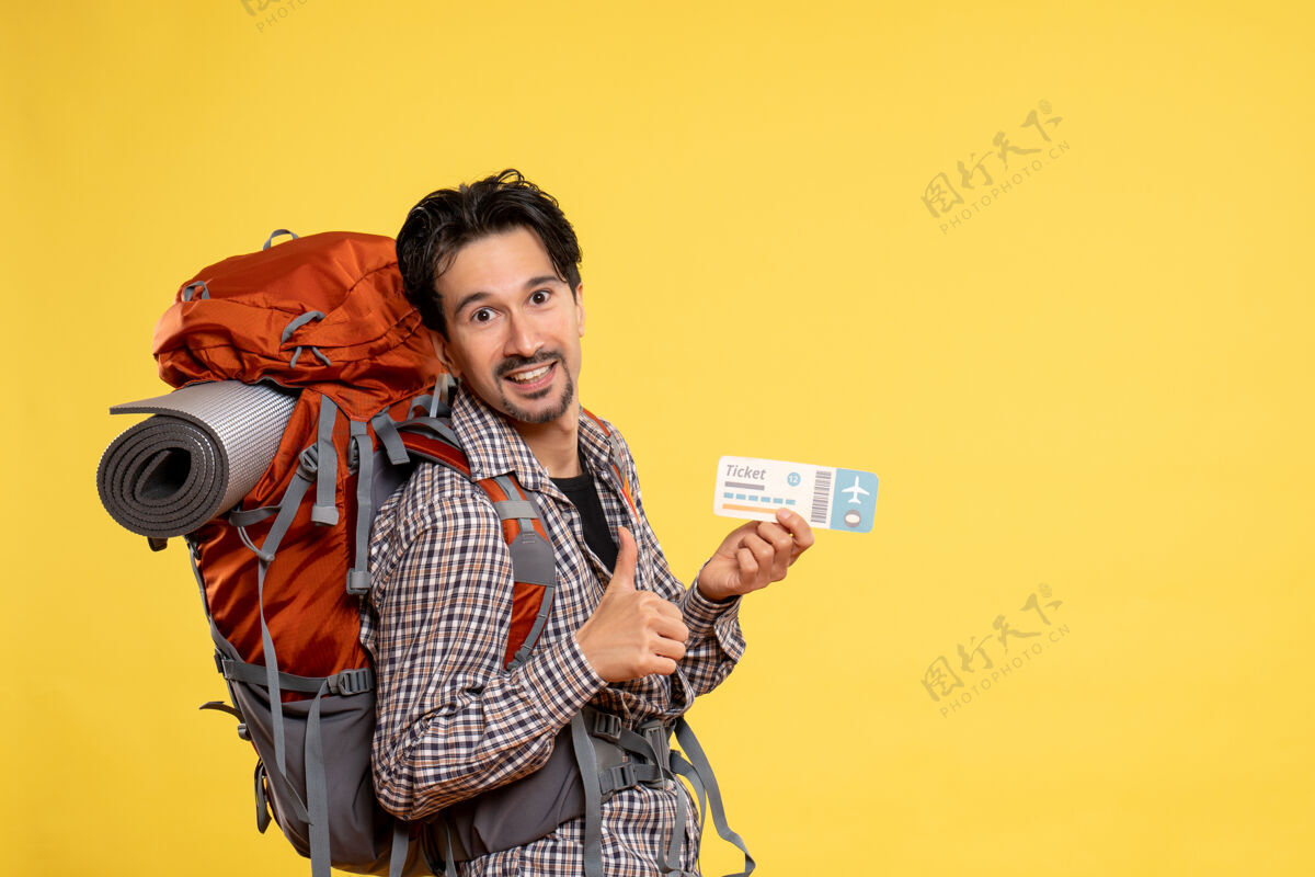 年轻男性正面图年轻男子背着背包拿着黄色的车票肖像自然人