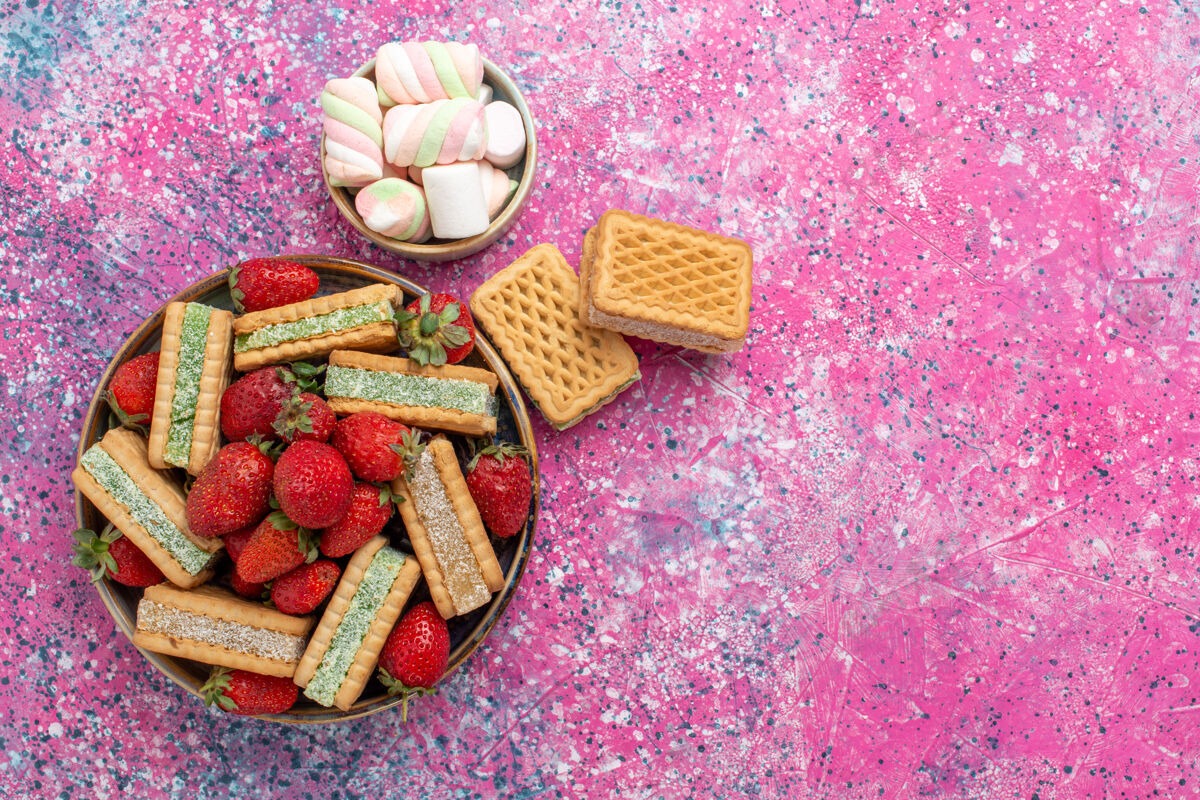 茶美味的华夫饼干顶视图 粉色表面有棉花糖和新鲜的红色草莓糖糖果华夫饼