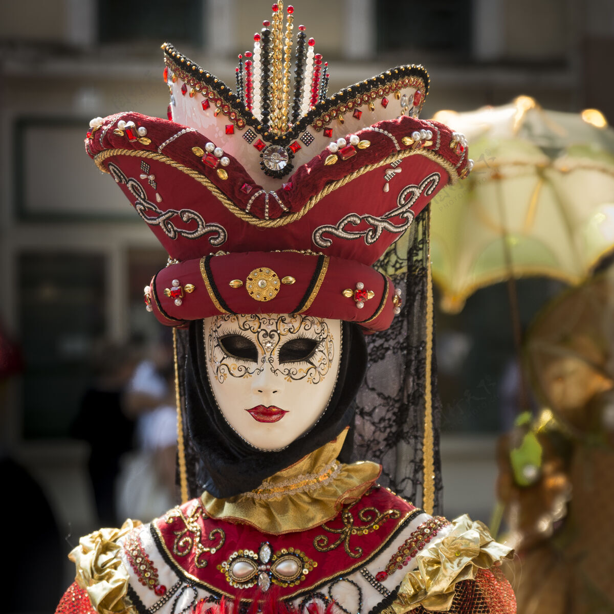 色彩一个人戴着威尼斯狂欢节面具和衣服的垂直镜头五颜六色帽子化妆舞会