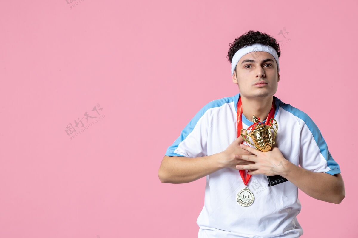 比赛正面图身穿运动服的年轻运动员 拿着奖牌和金杯粉红色杯男