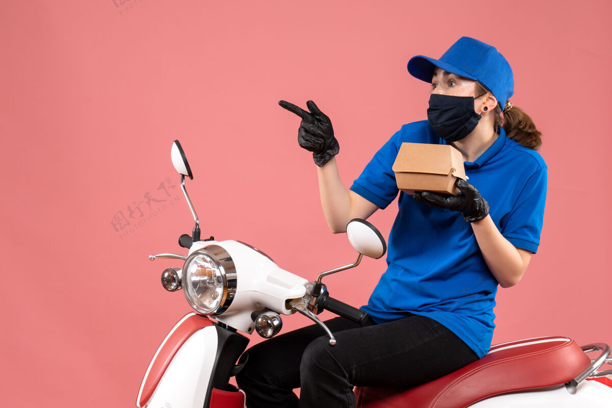 头盔正面是戴着面具的女快递员 粉红色的小食品包装包装流行病车辆