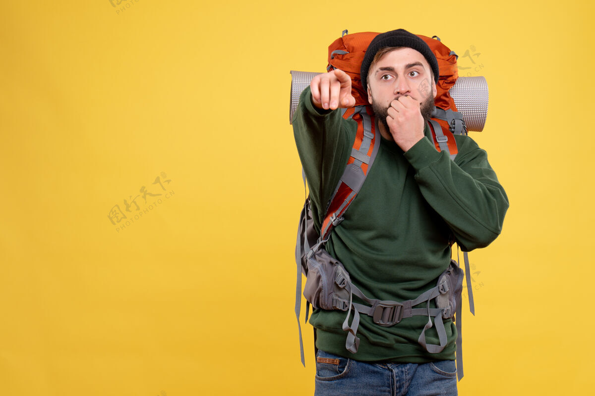顶旅行概念的俯视图 令人惊讶的年轻人背着背包指着前方娱乐旅行喜剧演员