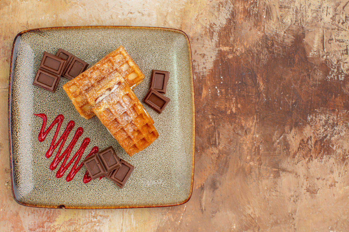 空白的俯瞰美味的华夫饼与巧克力条在棕色的背景纸巧克力年代