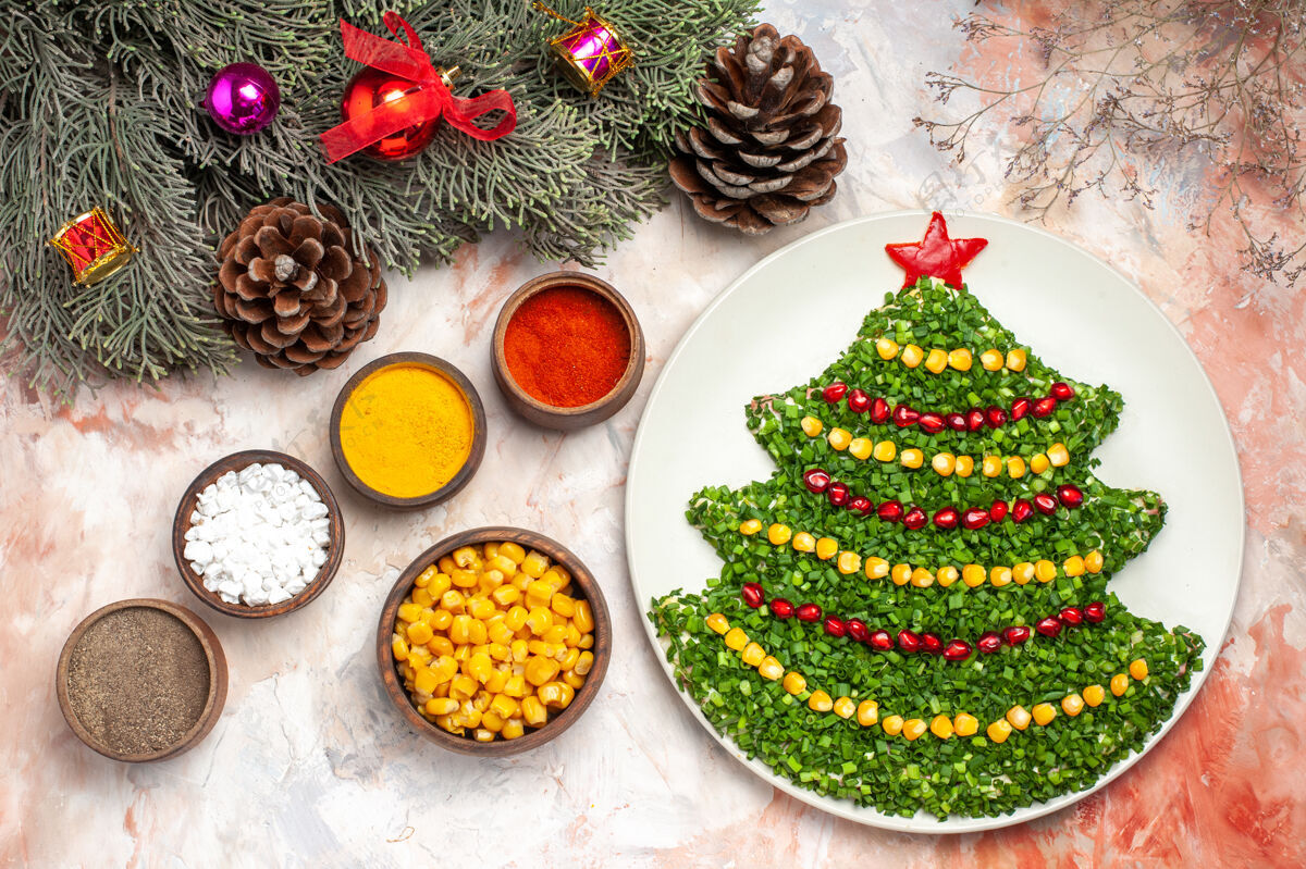 圣诞节顶视图美味的蔬菜沙拉在新年树形状与调味品在一个轻背景光胡椒粉新