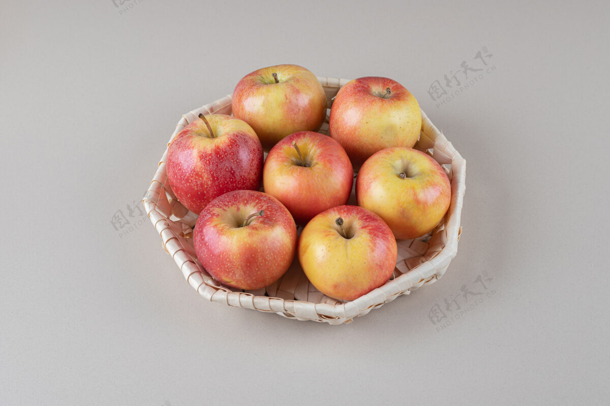 捆绑一捆苹果放在大理石上的篮子里营养美味篮子