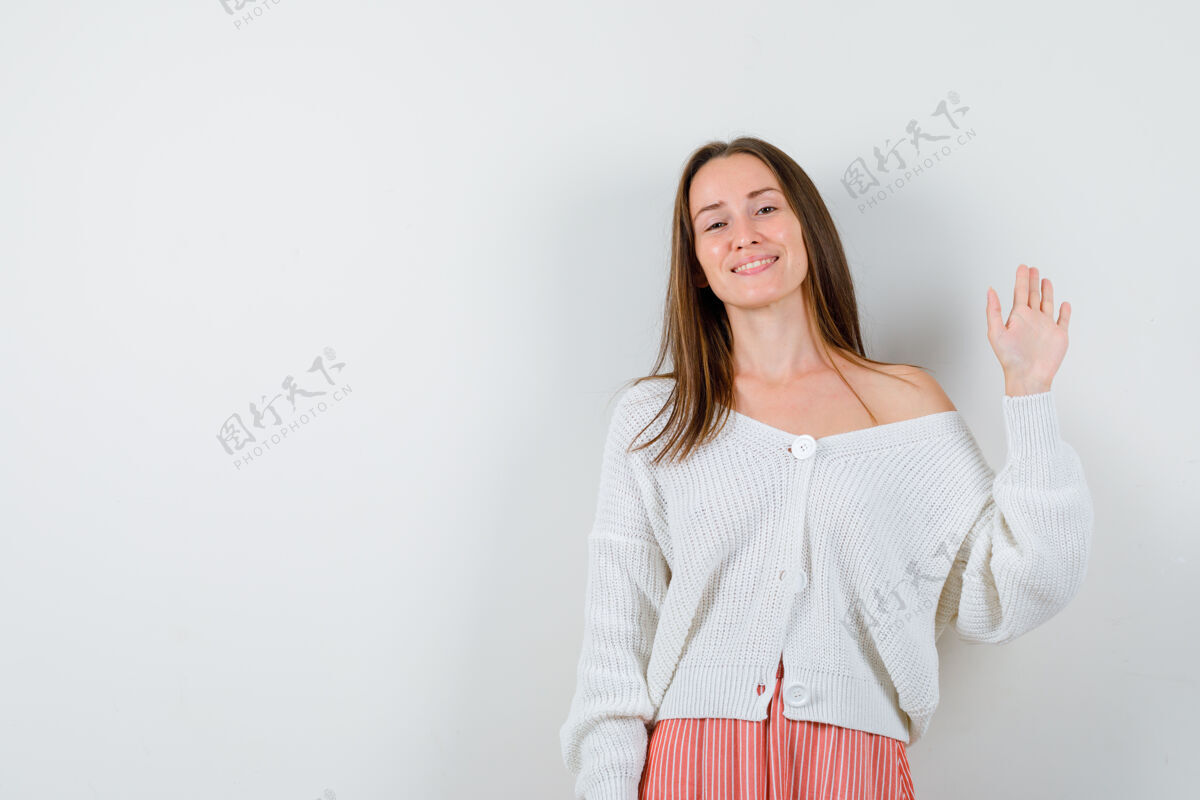 女士穿着开衫和裙子的年轻女性挥手致意 看起来很幸福孤立裙子美丽问候