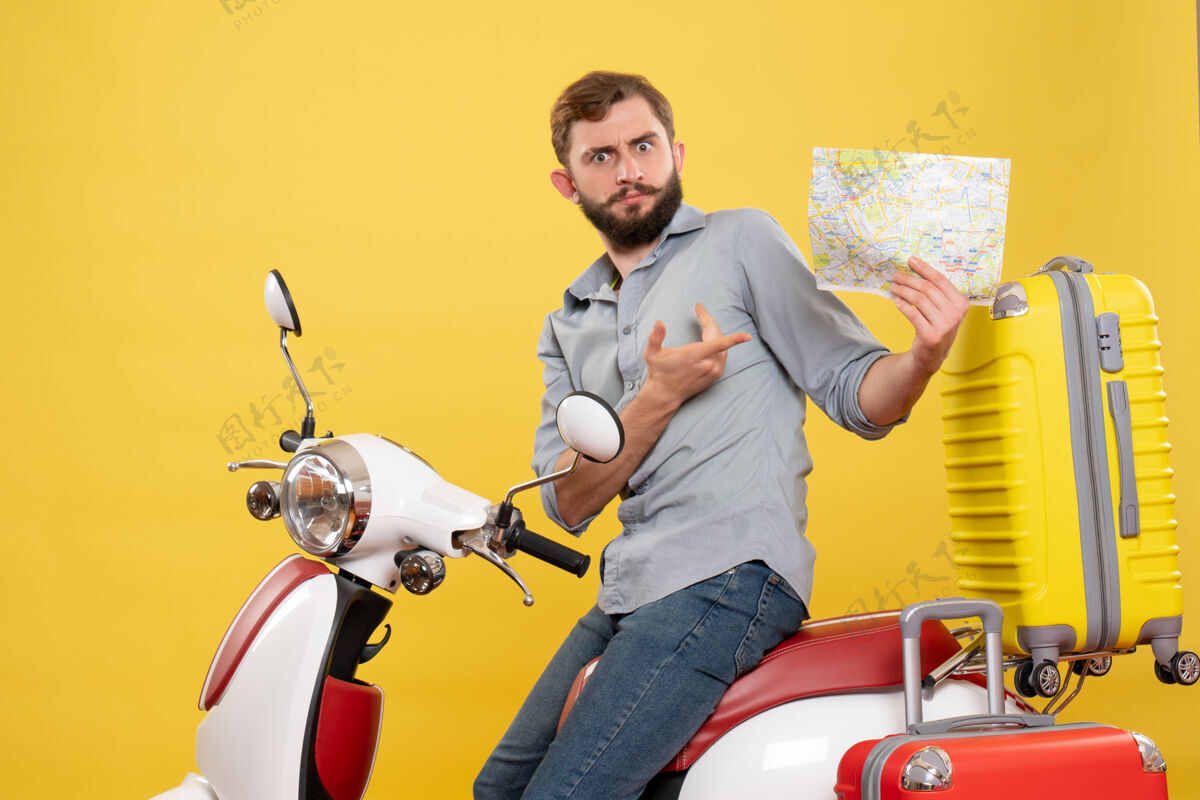 年轻人旅游概念的正面图 困惑的年轻人坐在摩托车上 手提箱放在上面 黄色的衣服上有人手提箱有人车辆