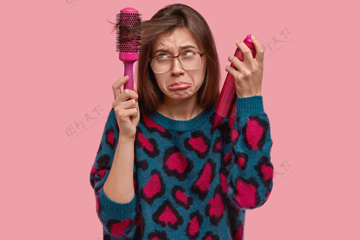 年轻穿彩色毛衣做发型的女人喷雾悲伤女人