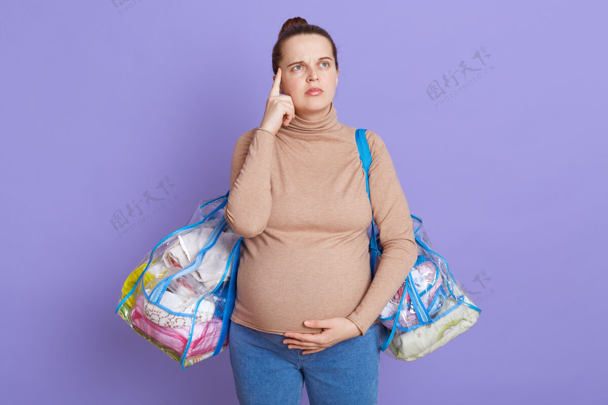 思想一幅体贴的孕妇画像 试图记起她把所有的东西都送到医院 手指放在太阳穴上 神情沉思地抬起头 隔着淡紫色的墙壁出生胃牛仔裤