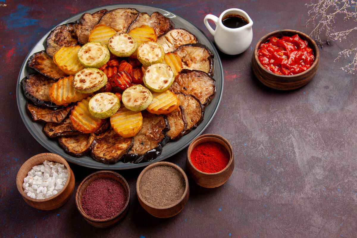 蔬菜顶视图烤蔬菜土豆和茄子与不同的调味品在黑暗的空间美味晚餐烤箱