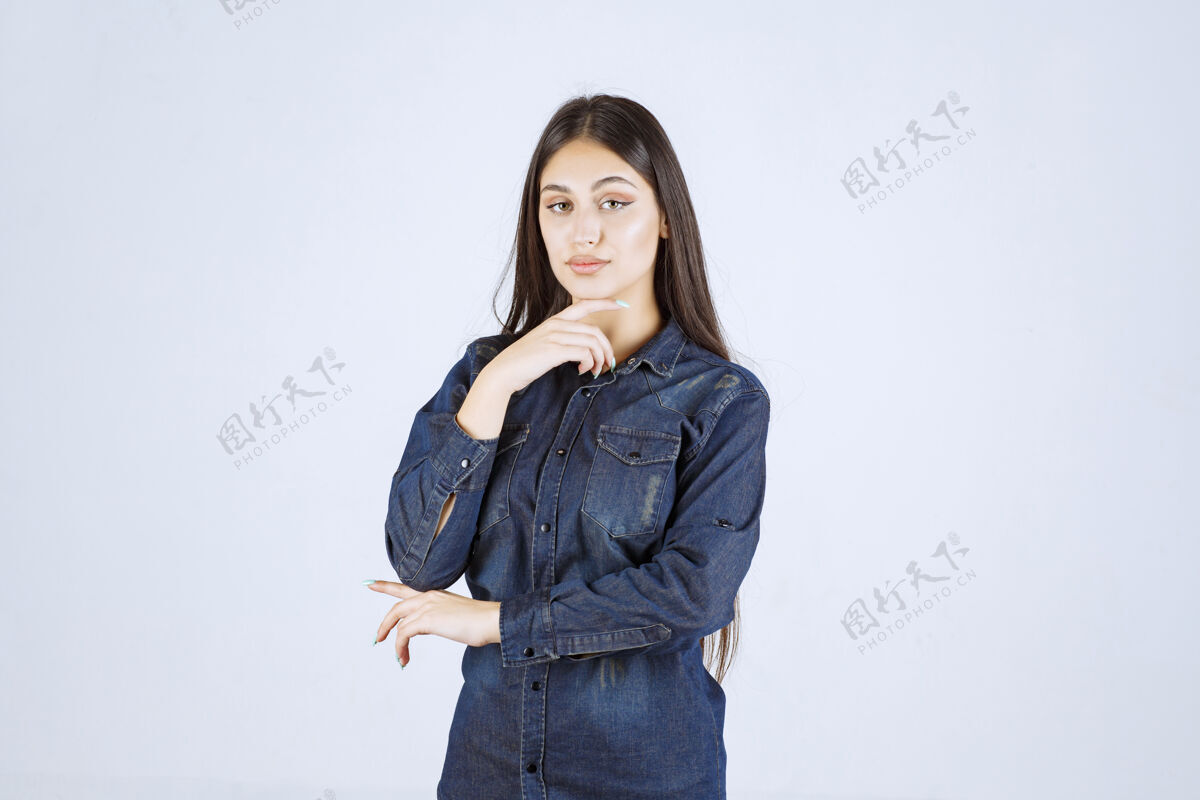 人类穿着牛仔衬衫的年轻女子摆出中性姿势 没有任何反应女人年轻放松