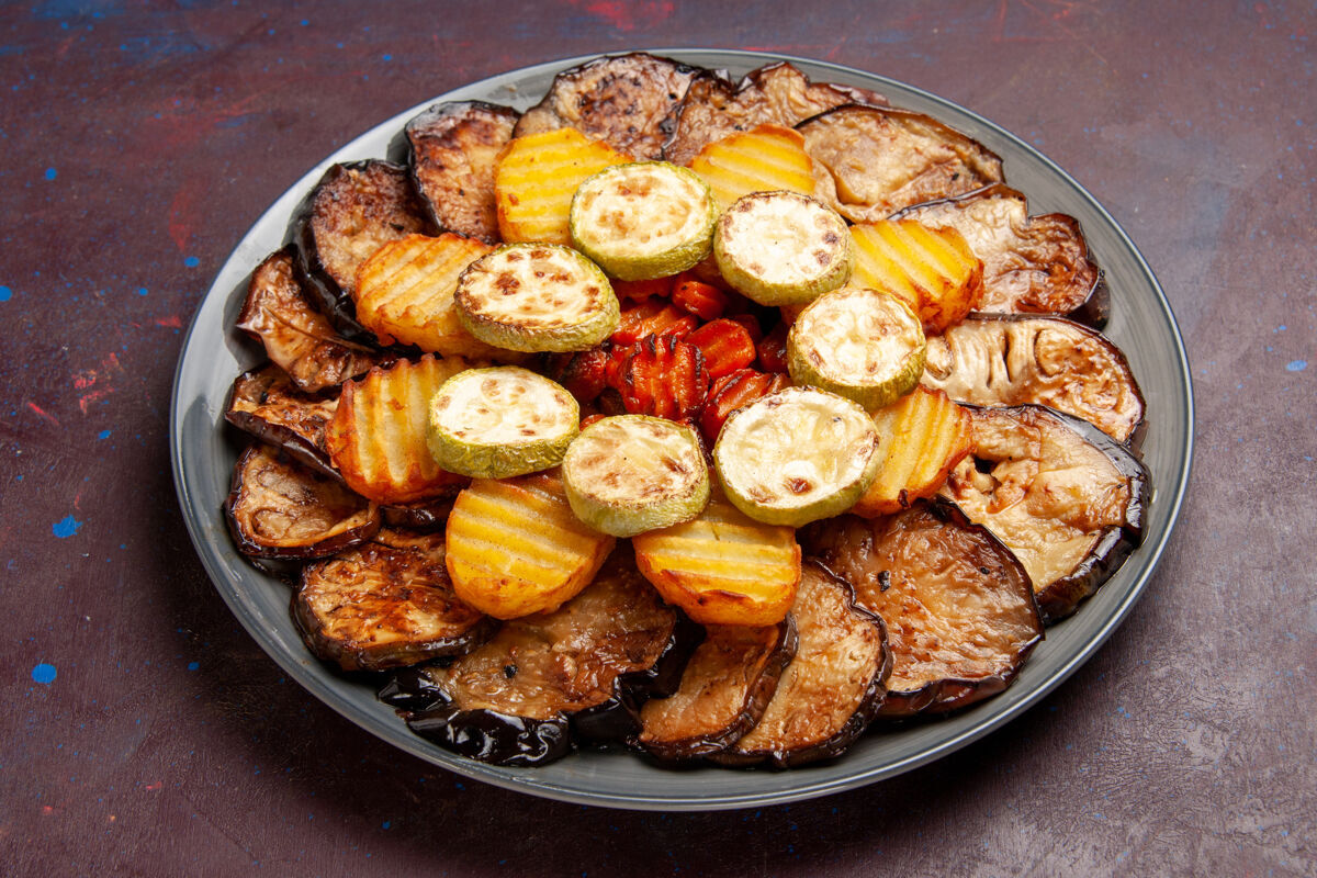 前前视图烤蔬菜土豆和茄子刚从黑暗的烤箱里出来新鲜肉美味