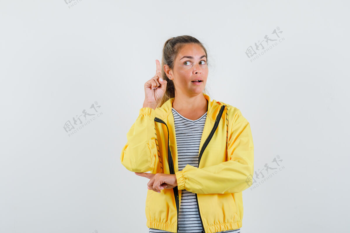 尤里卡金发女人举起食指在尤里卡手势在黄色轰炸机夹克和条纹衬衫 看起来岌岌可危美丽黑发漂亮