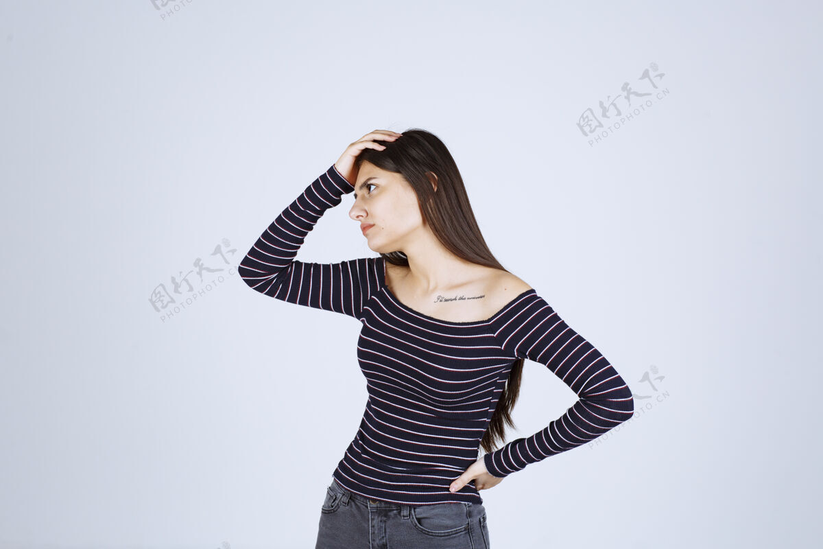 女人穿条纹衬衫的女孩在思考和分析服装人体模特预测