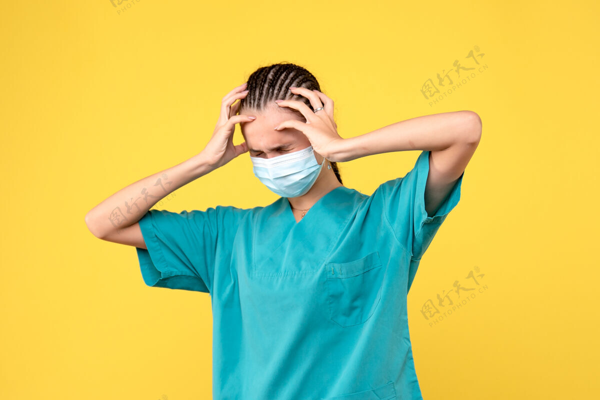 人正面图：穿着医用衬衫 戴着头痛面罩的女医生 大流行医院的健康护士covid-19医护人员头痛流行病女人