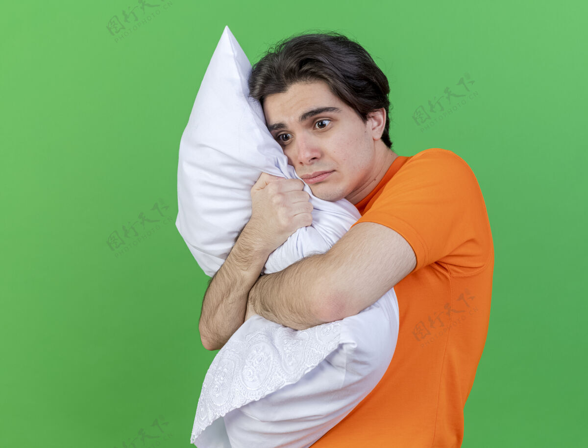 疾病看着身边年轻的病夫抱着一个被隔离在绿色背景上的枕头拥抱侧身抱枕