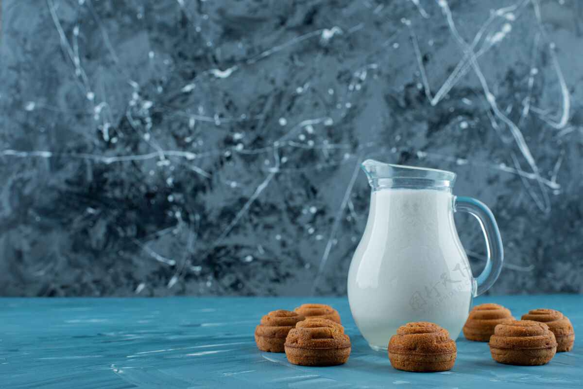 玻璃杯一杯新鲜牛奶 蓝色背景 甜甜的圆形饼干蓝色美味牛奶