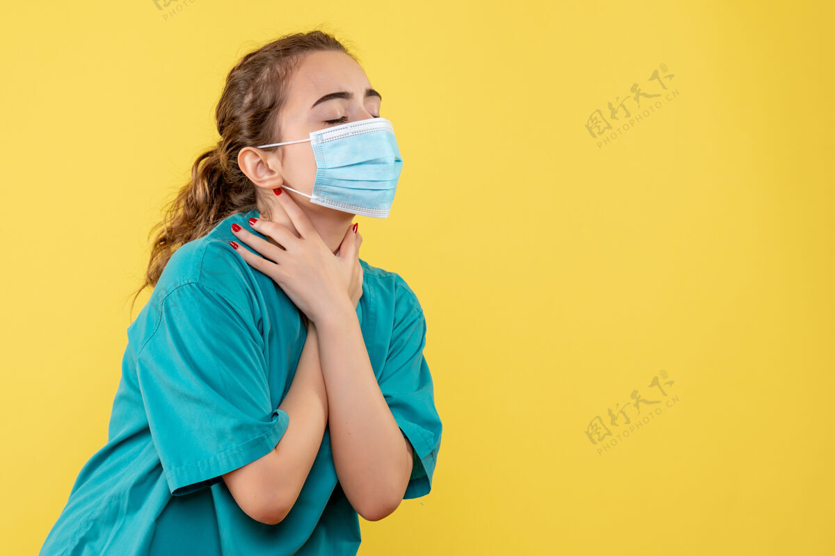 黄色前视图：女医生穿着医用衬衫和面罩 健康covid-19大流行色制服女性医疗面具