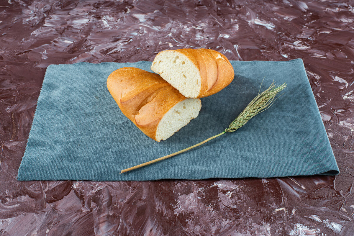 烘焙一块碎的白面包 背景是小麦穗金色面包小吃