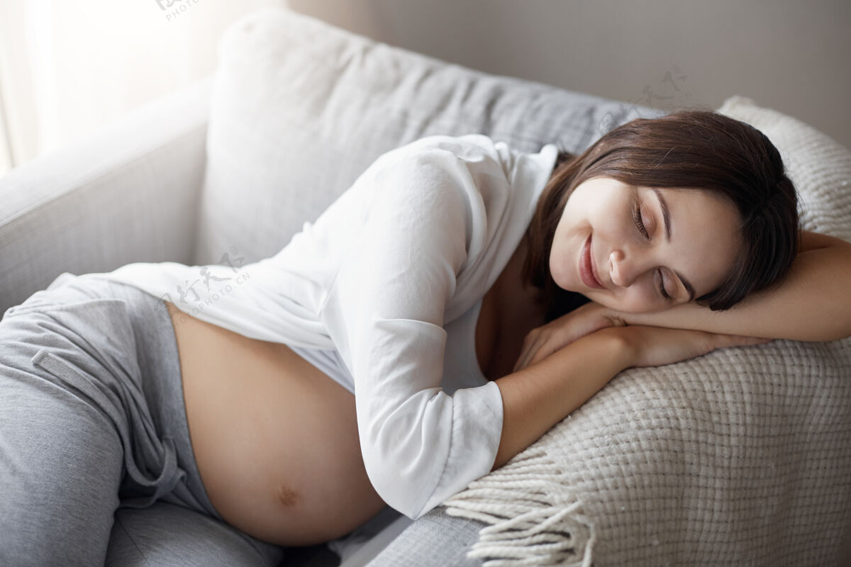 休息年轻的孕妇睡在扶手椅上快乐房子年轻