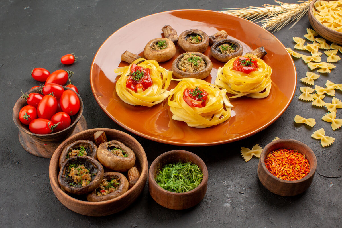 面团前视图煮熟的蘑菇和面团面食在一张深色的餐桌上正餐颜色肉晚餐午餐