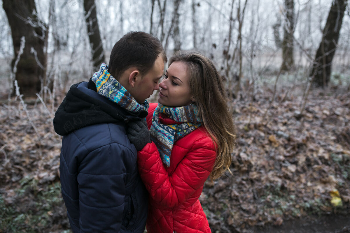 情侣这对夫妇在湖边的冬季森林里寒冷宁静手套