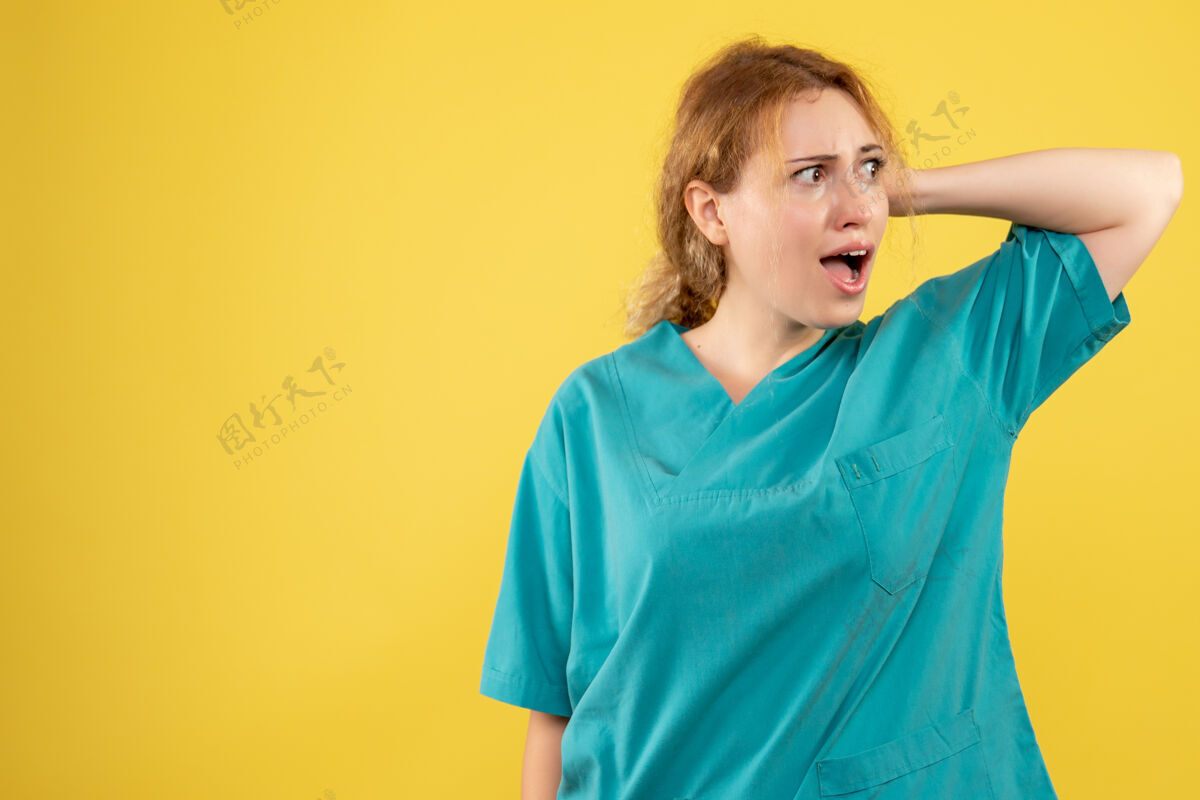 护士黄墙上年轻女医生穿着医用衬衫的正面图快乐前面微笑