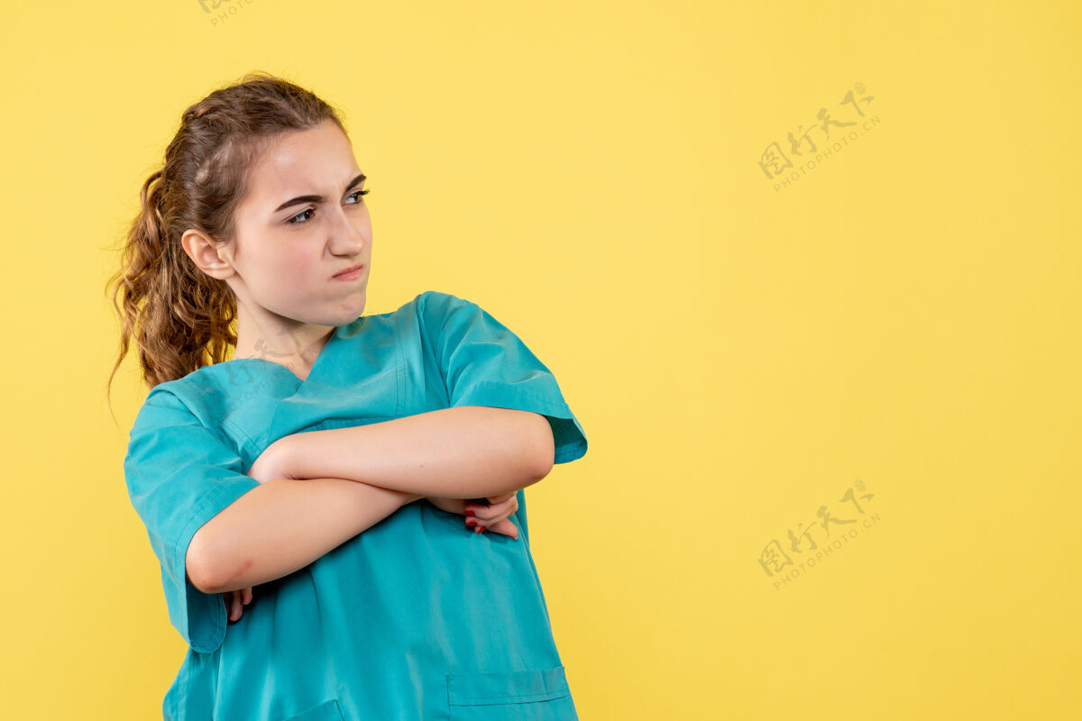 肖像黄墙上年轻女医生穿着医用衬衫不高兴的正面图年轻女医生医院休闲