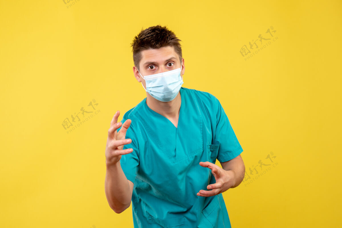 脸黄色墙上戴着防护面具的男医生的正视图保护健康人