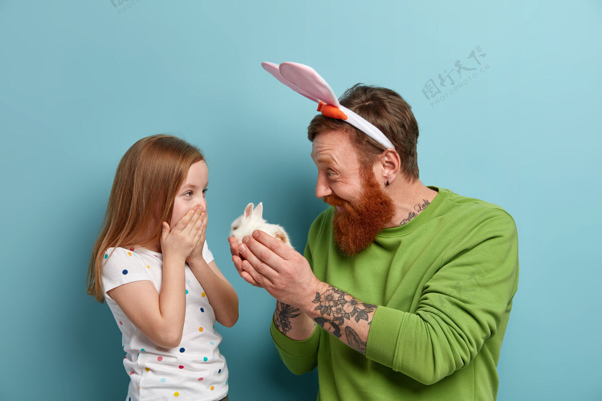 父亲快乐的爸爸把小毛绒兔送给女儿 做礼物玩男人快乐