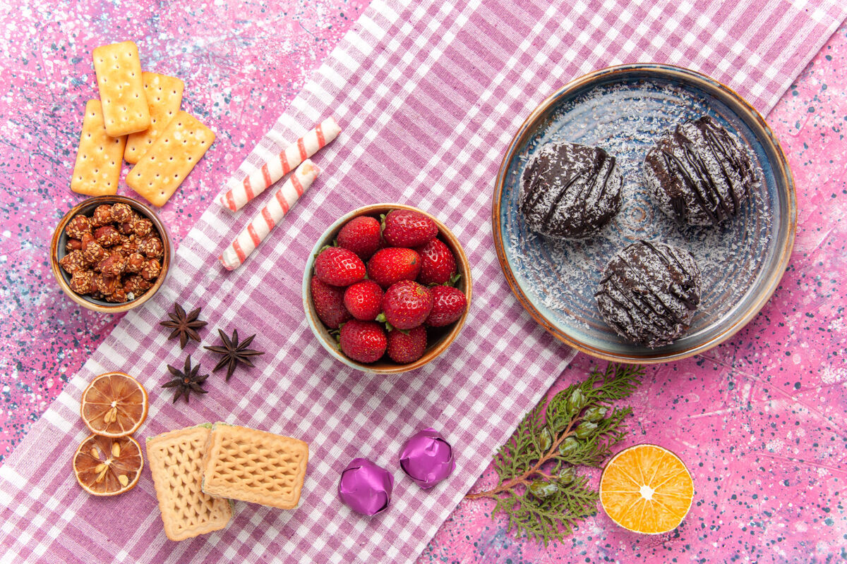 饼干顶视图美味的巧克力蛋糕与草莓粉红桌子蛋糕水果