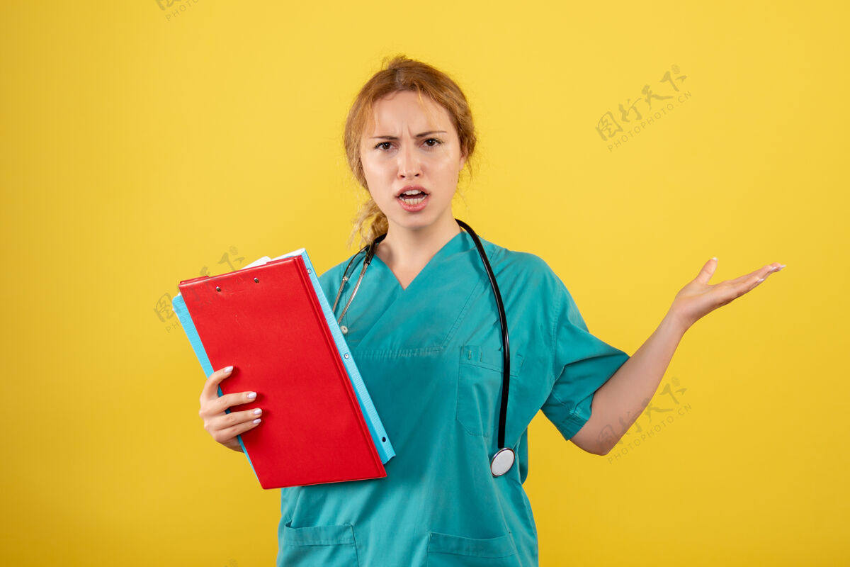 医院黄墙上穿着医疗服拿着不同分析的女医生正面图不同人病毒