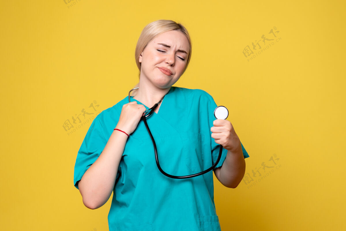 病毒黄色墙壁上穿着带听诊器的医用衬衫的女医生的正视图疾病女医生医院