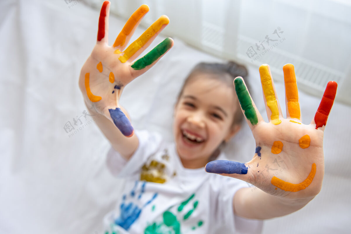 快乐在一个小女孩的手掌上画出微笑在孩子们的手掌上画出有趣明亮的图画手有趣女孩