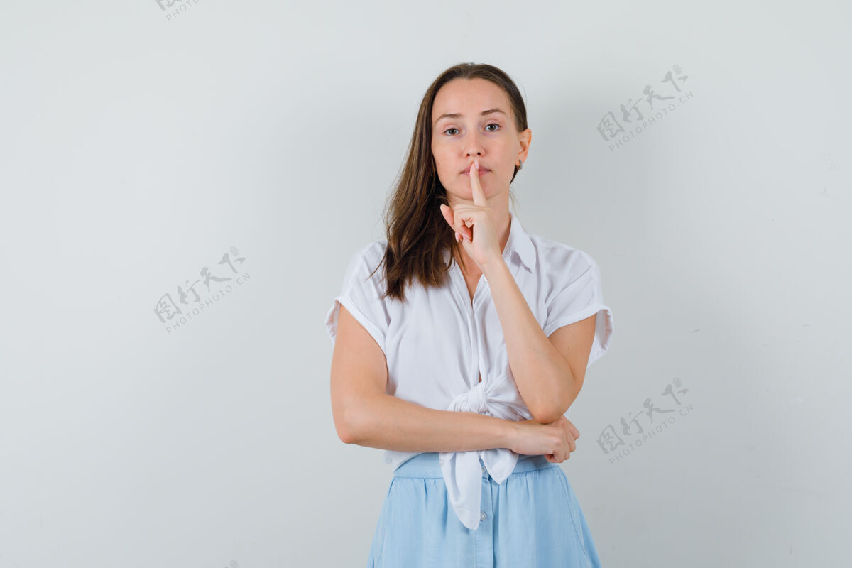 水疗一位身穿白衬衫和浅蓝色裙子的年轻女士 她表现出沉默的姿态 表情严肃女人显示头发