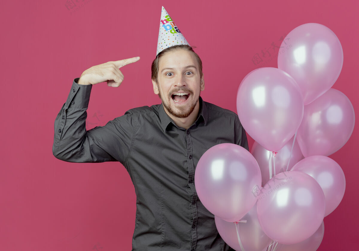 指向戴着生日帽的帅哥站在那里 氦气球指着帽子生日气球惊喜