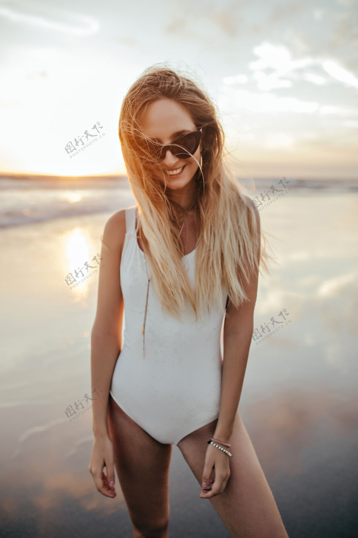 太阳在海滩上笑着的金发女人女士模特放松