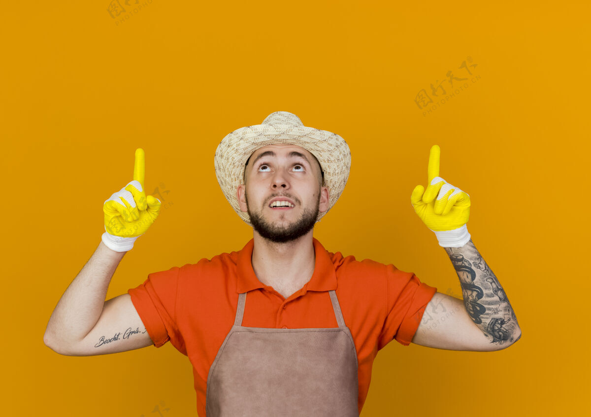 点惊讶的男园丁戴着园艺帽和手套点了起来复制向上橙色