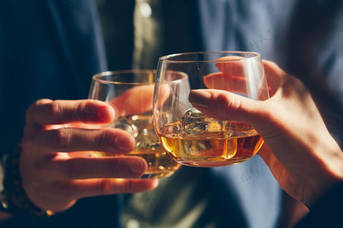 祝酒两个人在祝酒时用酒精碰杯的特写镜头香槟酒杯休闲