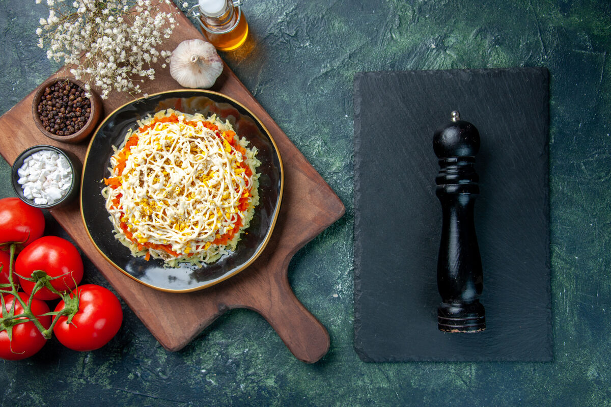 风景顶视图美味含羞草沙拉在盘子里与深蓝色背景上的红色西红柿晚餐香料深蓝色