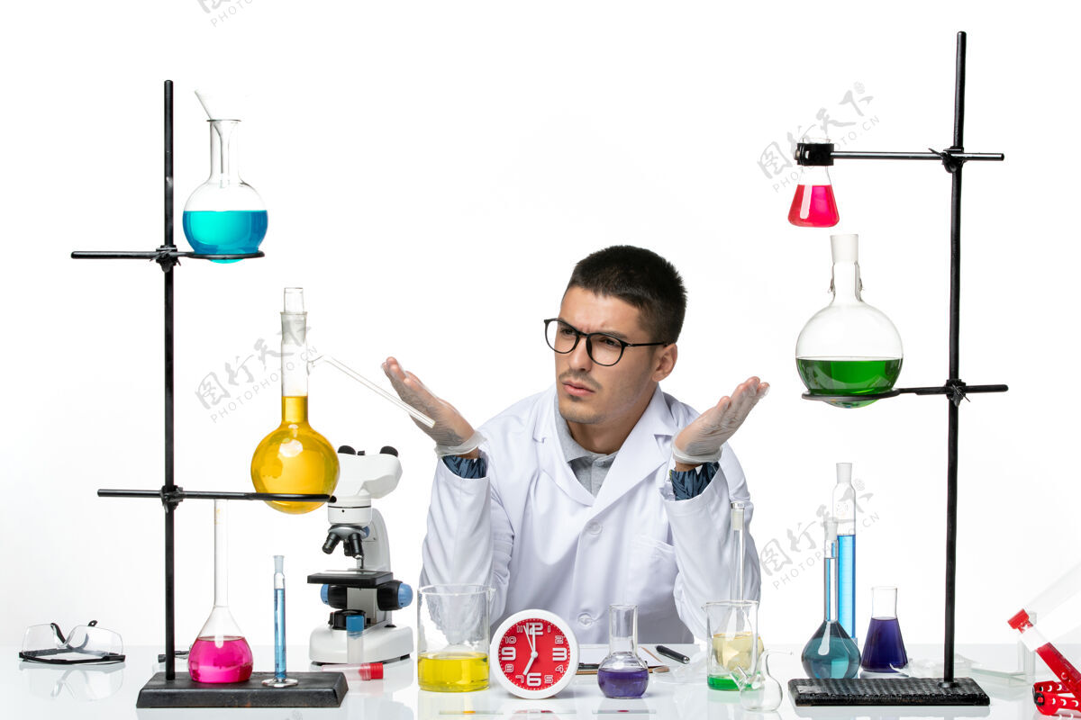 疾病正面图身着白色医疗服的男性化学家坐在浅白背景上 用不同的溶液研究病毒疾病科学实验室的科维德人解决方案不同
