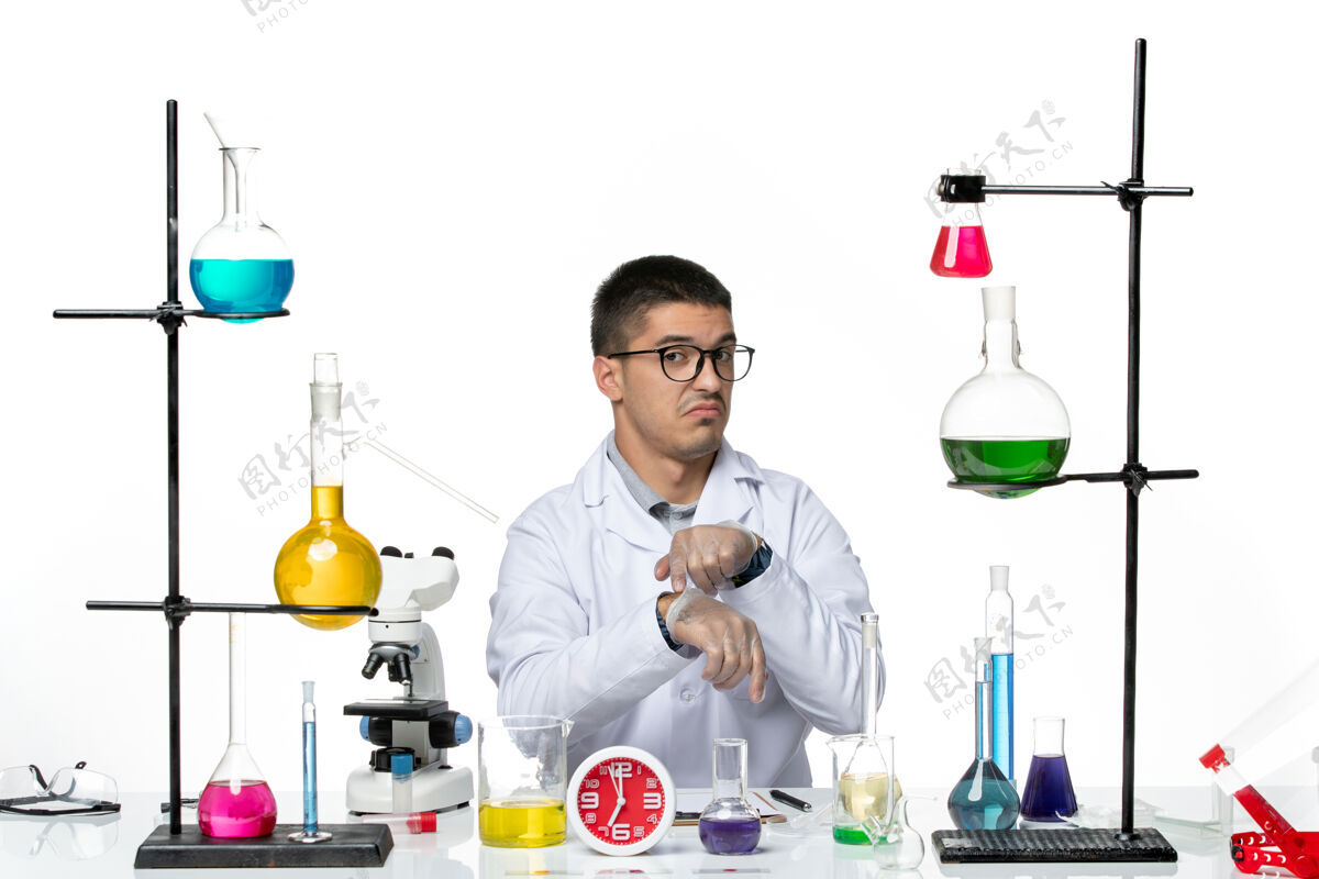 地板正面图：穿着白色医疗服的男性化学家坐在白色地板上 拿着不同的溶液病毒疾病科学实验室医生人实验室