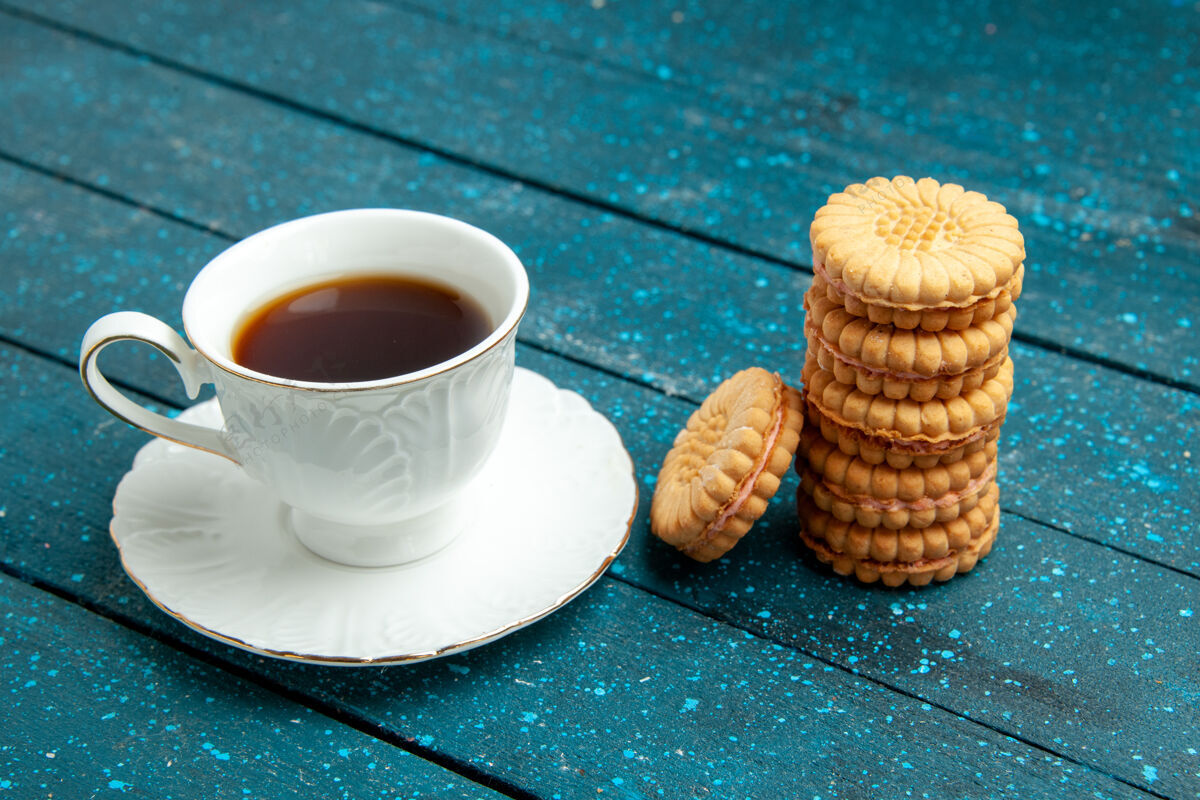 桌子一杯茶加饼干放在蓝色的乡村书桌上茶糖饼干饼干乡村的早餐浓缩咖啡