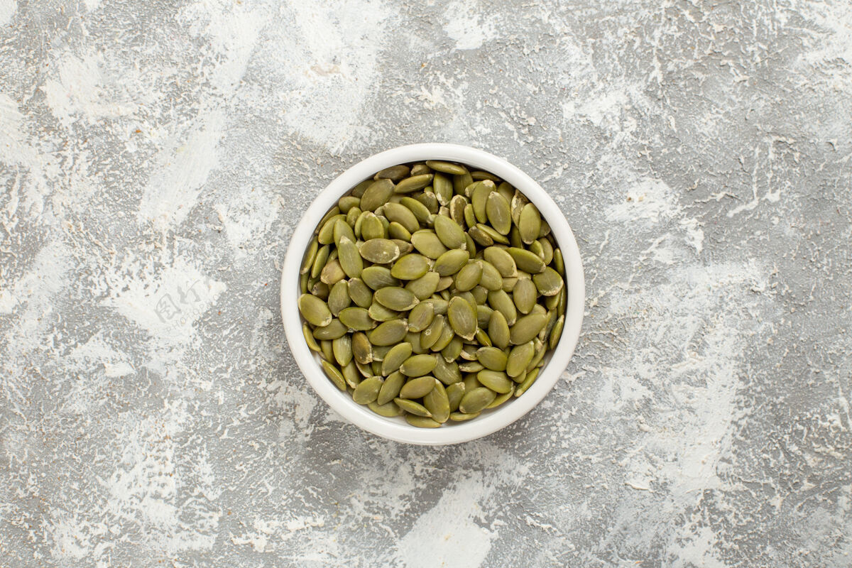 健康顶视图绿色种子从南瓜上白色背景的种子绿色照片南瓜开心果咖啡