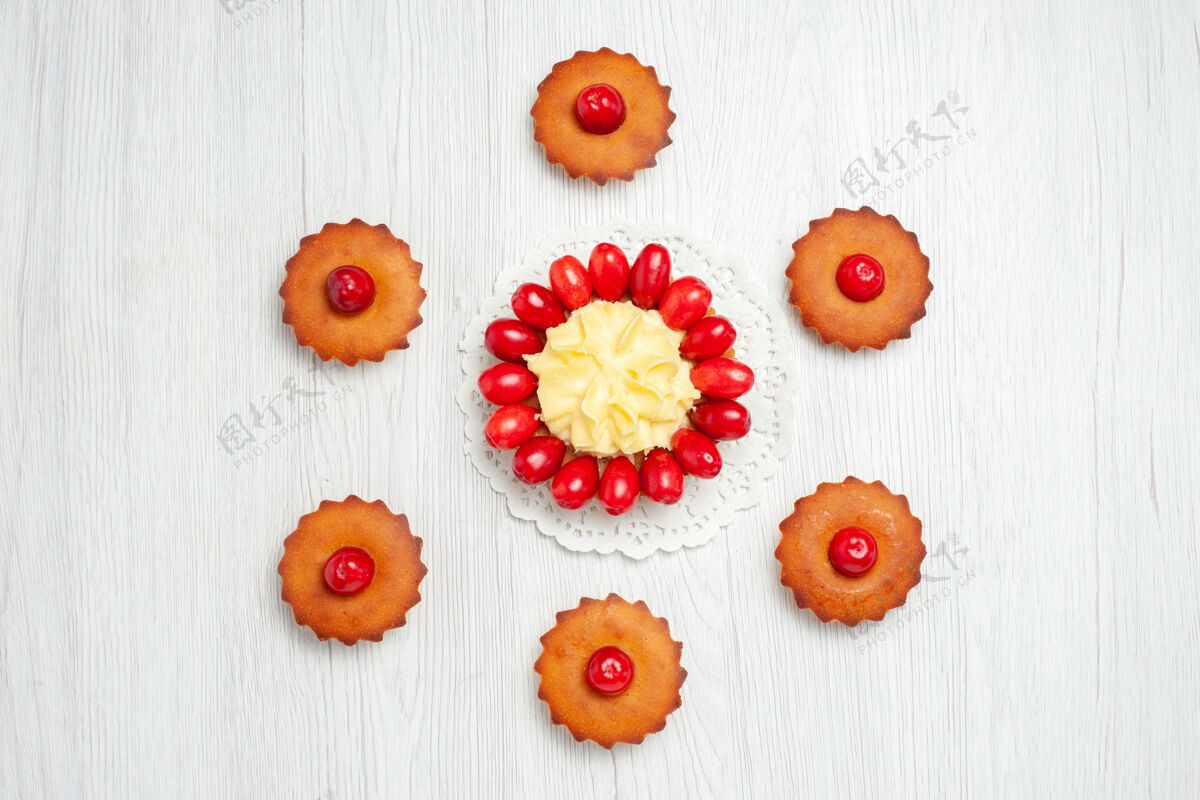桌子俯瞰白色桌子上有山茱萸和蛋糕的奶油蛋糕帽子水果花