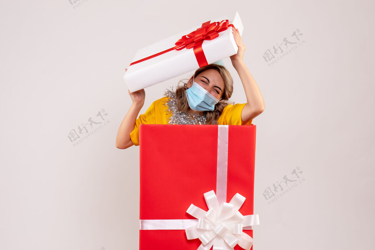 面具正面图：戴着面具的红色礼品盒里的年轻女性礼物流行包